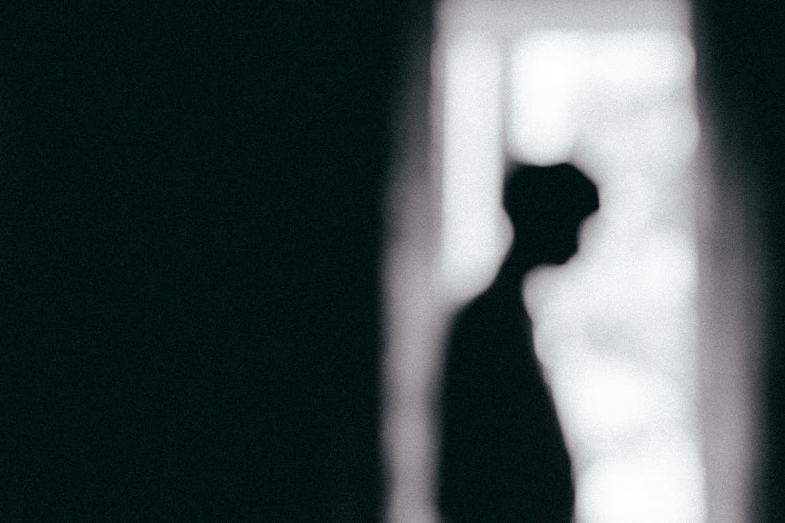 Silhouette of person in dark path